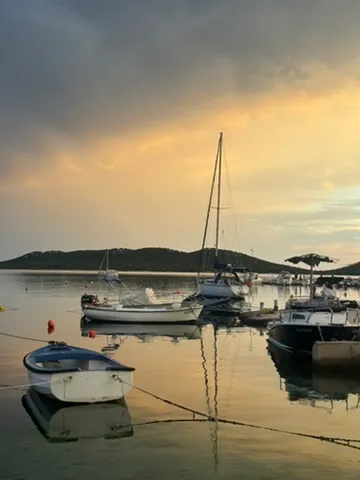 Sailing boats in the small Drage harbor at golden hour
