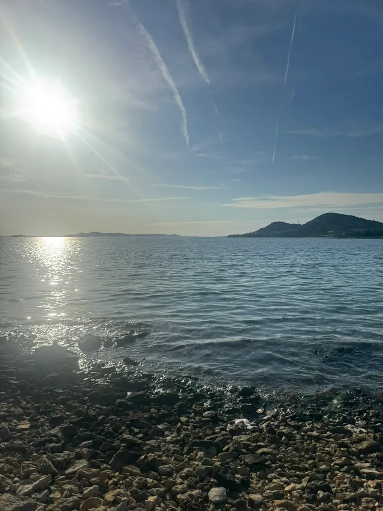 Rocky Drage shore with sun over the Adriatic Sea