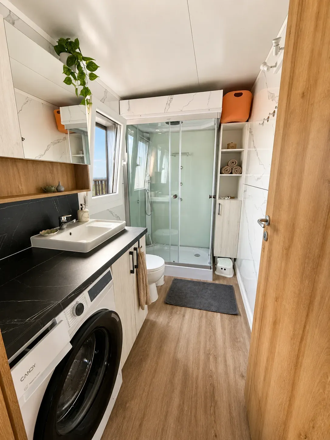 Bathroom with shower cabin, washing machine and vanity
