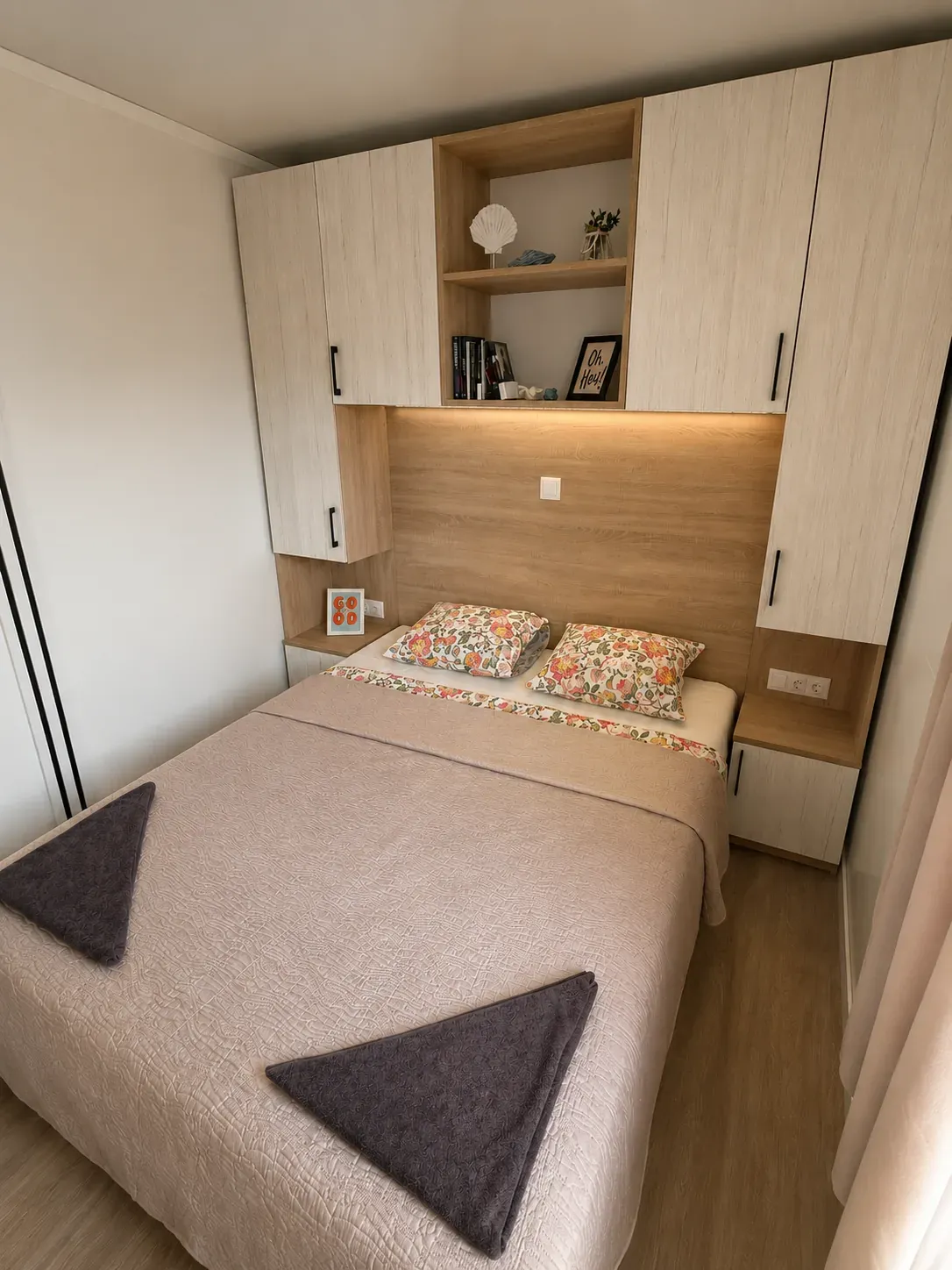Double bedroom with floral pillows and reading light