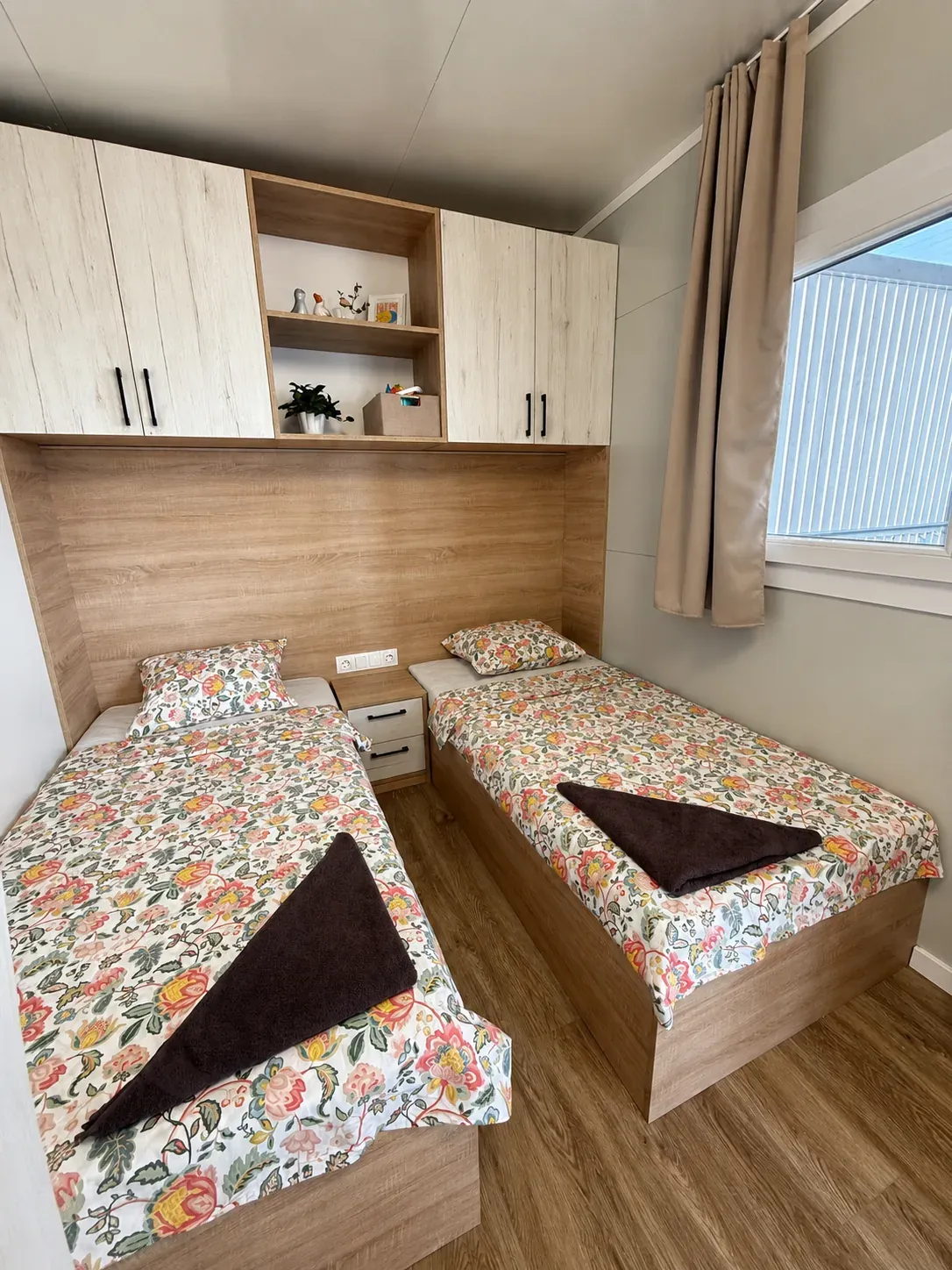 Twin bedroom with two single beds and overhead cabinets