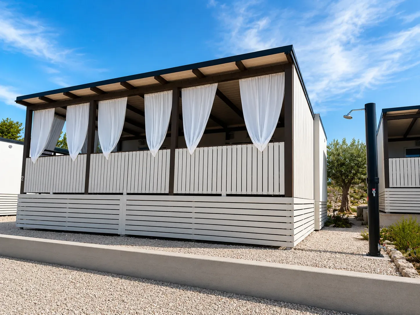 Exterior of the Julia house with covered terrace and outdoor shower