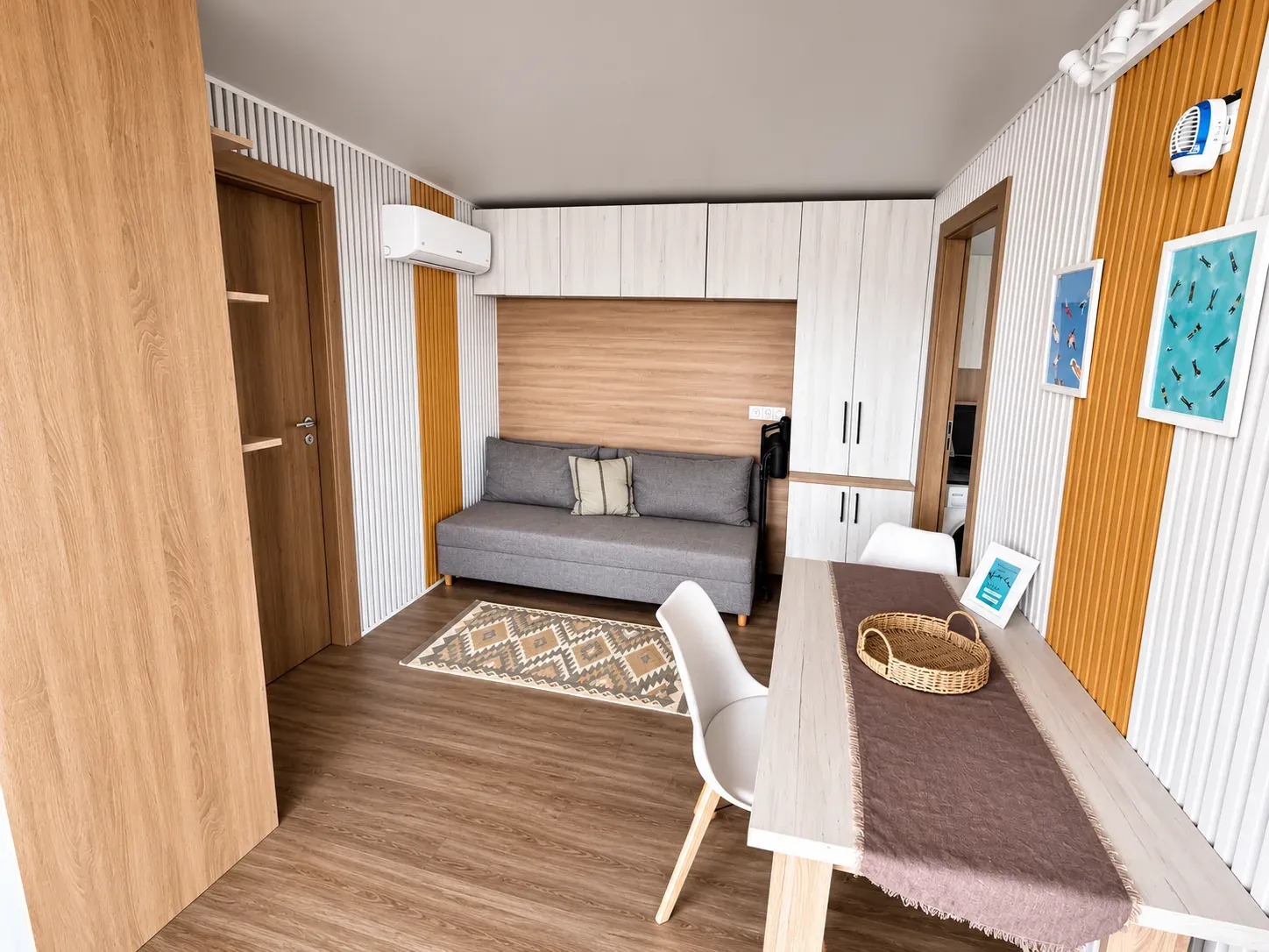 Living area with sofa bed, dining table and air conditioning